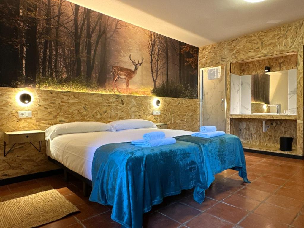 a bedroom with a bed and a painting of a deer at Albergue Real Fabrica de Ezcaray in Ezcaray