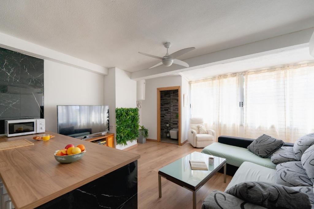 un soggiorno con divano e tavolo di Apartamento villa playa a Benidorm
