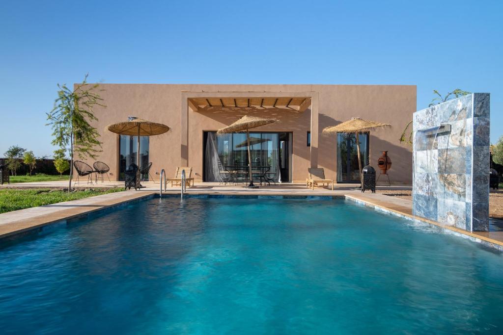 a swimming pool in front of a house at Ezz Dar Marrakech Villa Piscine sans vis a vis Private Pool pour Familles & Couples mariés in Thata