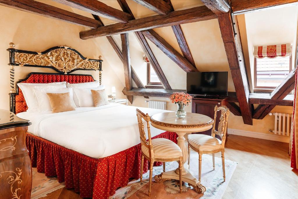 a bedroom with a large bed with a table and chairs at Alchymist Grand Hotel and Spa - Preferred Hotels & Resorts in Prague