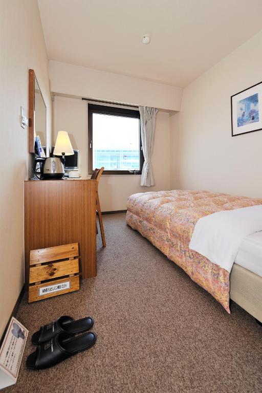 Postel nebo postele na pokoji v ubytování Hotel Keifuku Fukui Ekimae