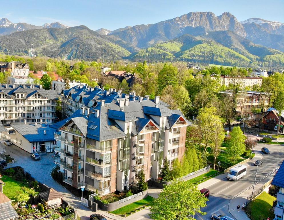 an aerial view of a building with mountains in the background at Apartamenty & Spa Stara Polana in Zakopane