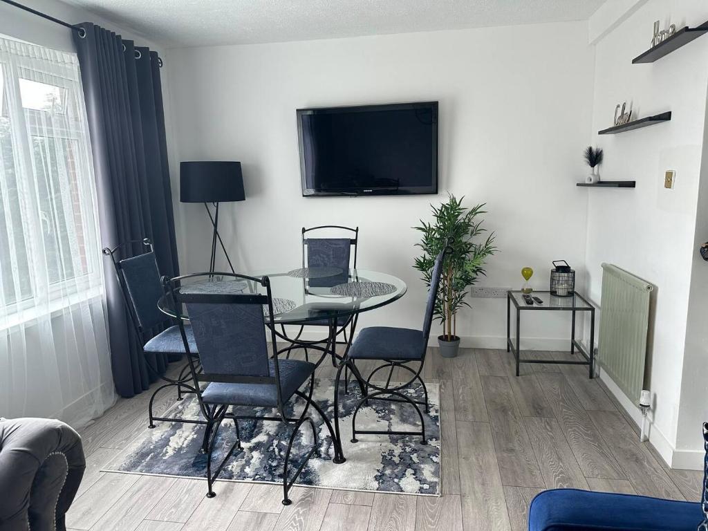 a living room with a table and chairs and a tv at Sunny Apartment In Cheltenham in Cheltenham