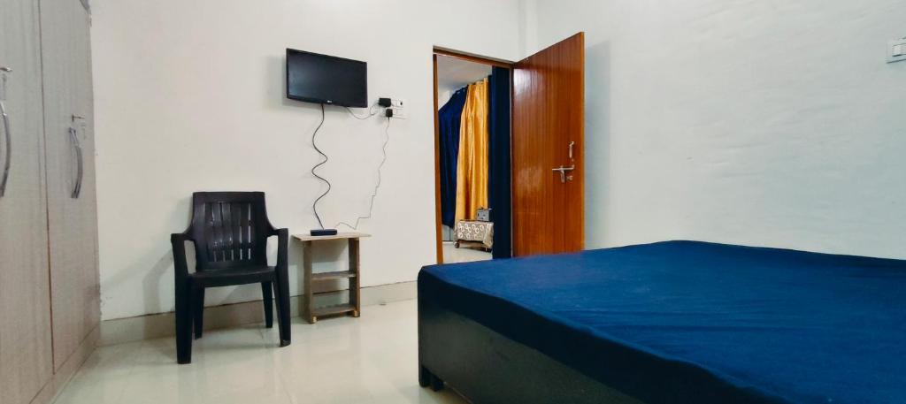 um quarto com uma cama, uma cadeira e uma televisão em Advik cottege em Rāmnagar