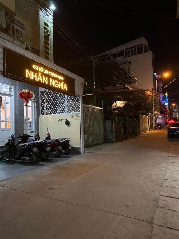 ein Gebäude mit Motorrädern, die nachts draußen geparkt sind in der Unterkunft Nhà nghỉ Nghĩa Nhân in Da Lat