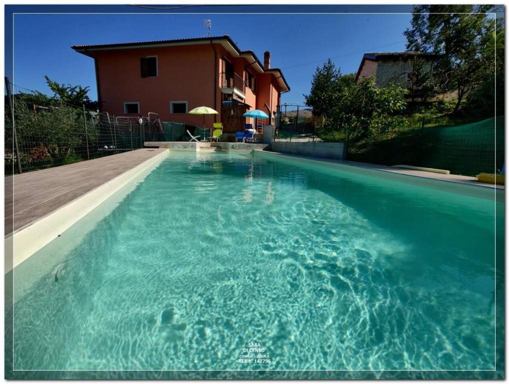 - une piscine d'eau bleue en face d'une maison dans l'établissement 3 bedrooms house with private pool terrace and wifi at Abbateggio, à Abbateggio