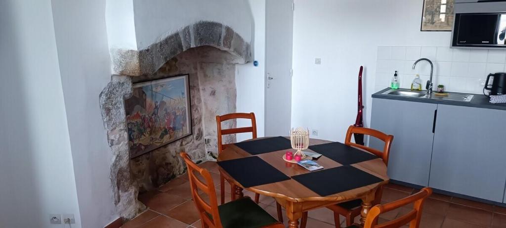 a table and chairs in a kitchen with a fireplace at Chez Adèle in Le Mont Saint Michel