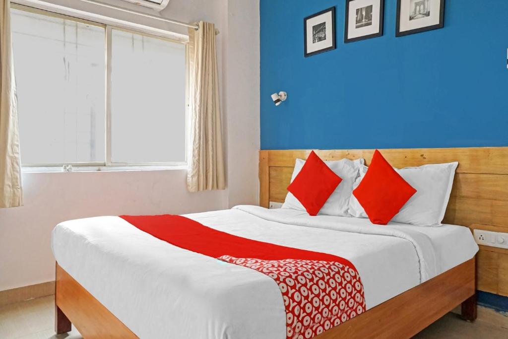 una camera da letto con un grande letto con cuscini rossi di OYO Flagship 84826 Hotel Silver Key a Méribel Village