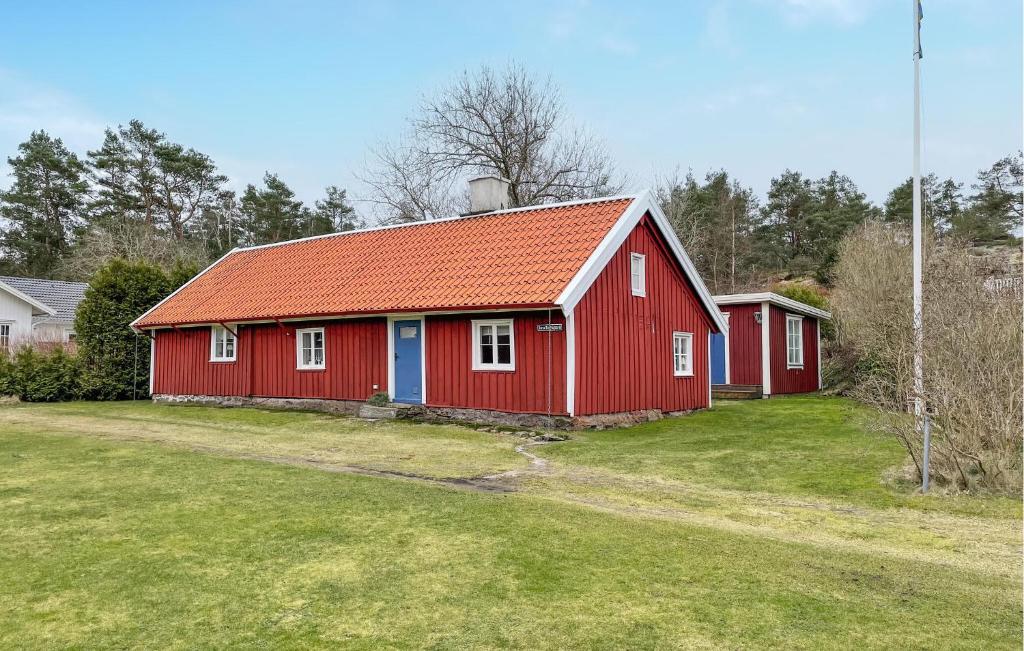 a red barn with an orange roof on a field at 3 Bedroom Gorgeous Home In Frilless in Frillesås
