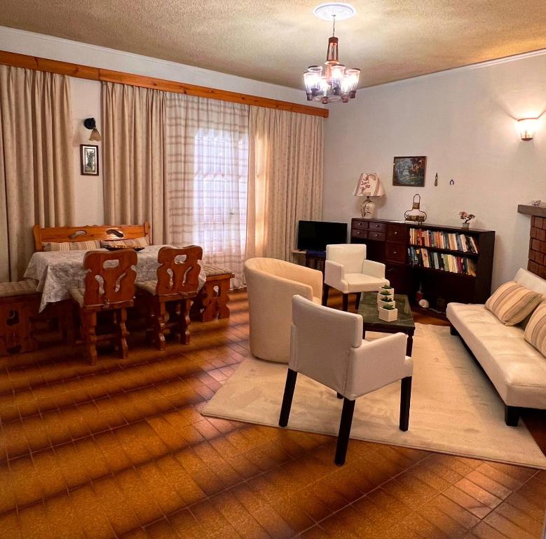 un soggiorno con divano, tavolo e sedie di Stefanos Apartments by SV Alians ad Agios Gordios