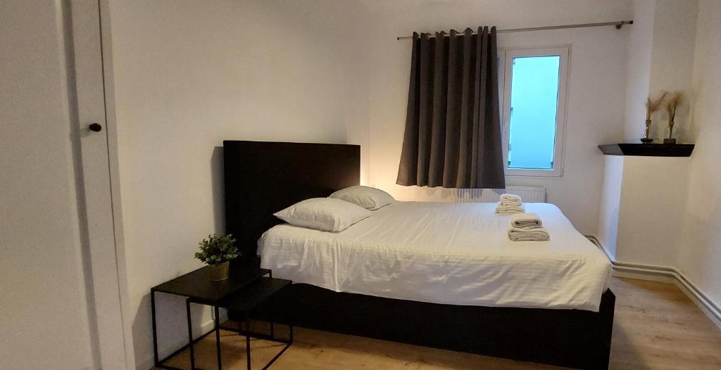 una camera da letto con un letto con lenzuola bianche e una finestra di The View - spacious 2 bdr appt in with view ad Anversa
