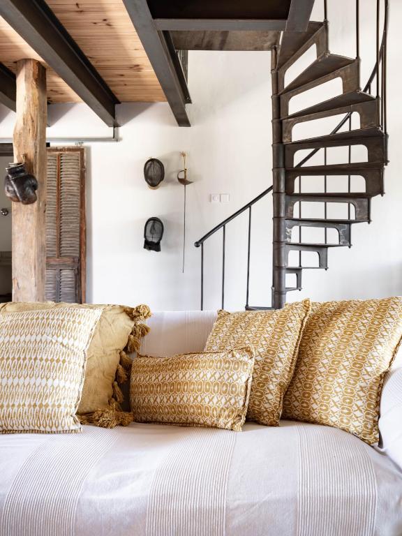 a living room with a white couch with pillows at Bassiviere Barn Chic in Saint-Étienne-de-Villeréal