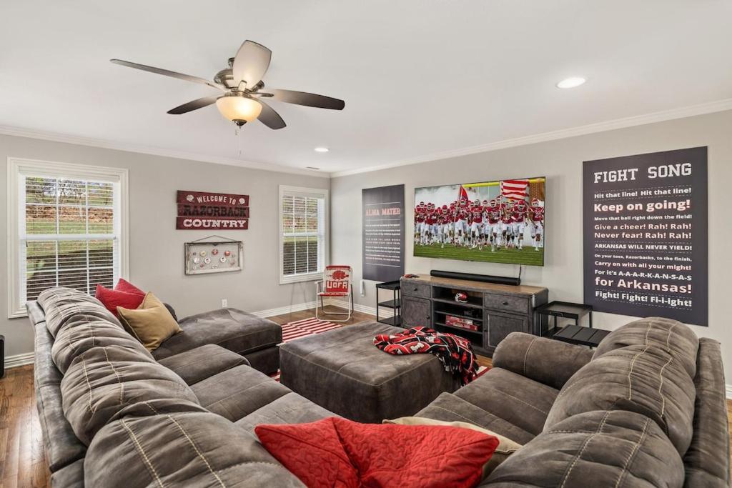 uma sala de estar com um sofá e uma televisão de ecrã plano em Pig Sooie Porch-Steps to Razorback Stadium-U of A em Fayetteville