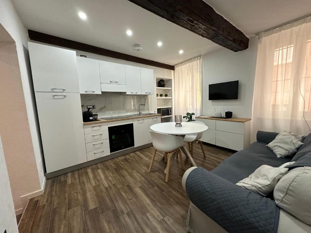 kuchnia i salon z kanapą i stołem w obiekcie Residenza Castellazzo w mieście Ivrea