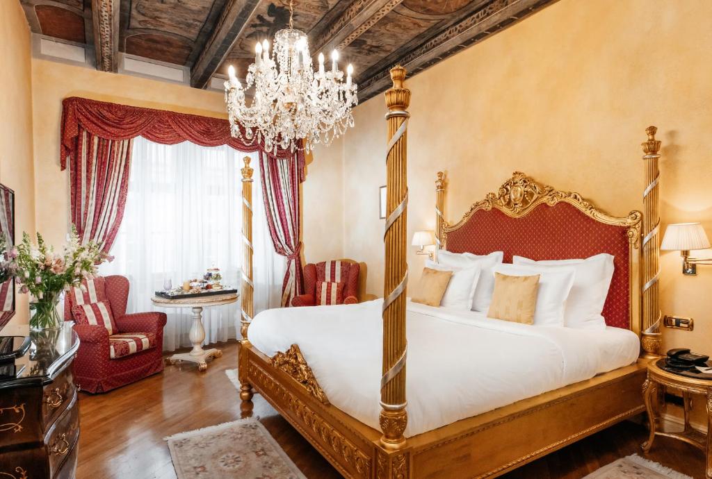 a bedroom with a large bed and a chandelier at Alchymist Grand Hotel and Spa - Preferred Hotels & Resorts in Prague