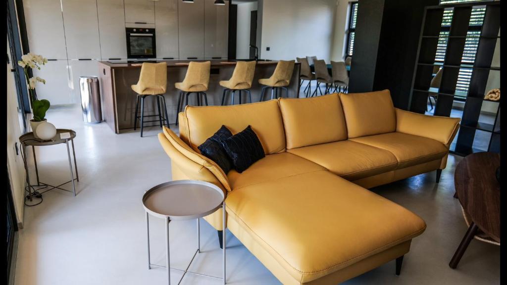 ein Wohnzimmer mit einem gelben Sofa und einer Küche in der Unterkunft Maison 21 in Zutzendorf