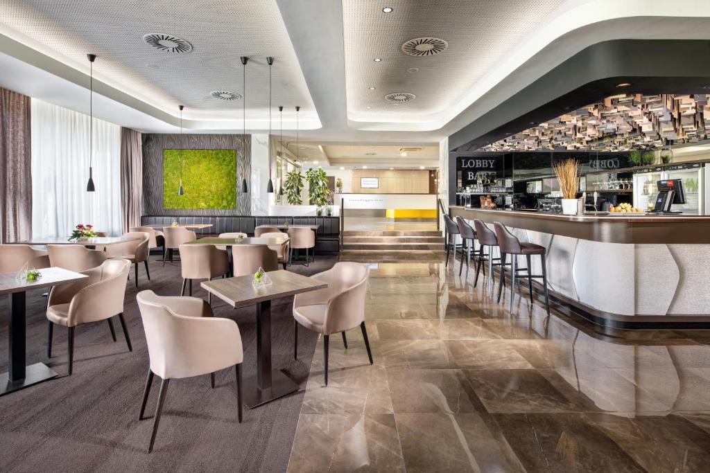 a restaurant with tables and chairs and a bar at Clarion Congress Hotel České Budějovice in České Budějovice