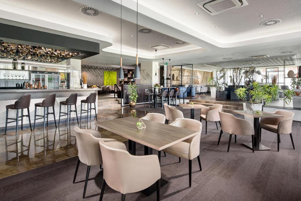 a restaurant with tables and chairs and a bar at Clarion Congress Hotel České Budějovice in České Budějovice