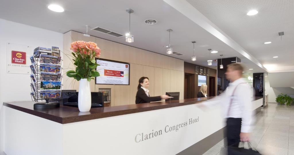 a man walking past a reception counter in a lobby at Clarion Congress Hotel České Budějovice in České Budějovice