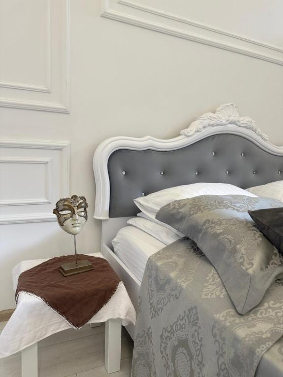 een witte slaapkamer met een bed met een zilveren hoofdeinde bij Vintage apartment in Lviv