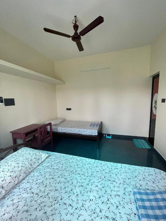 a bedroom with two beds and a ceiling fan at Countryside inn in Tiruvankod
