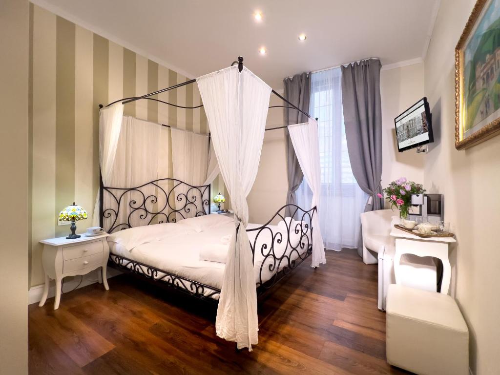 - une chambre avec un lit à baldaquin et du parquet dans l'établissement Il Terrazzino sulla Cattedrale, à Florence