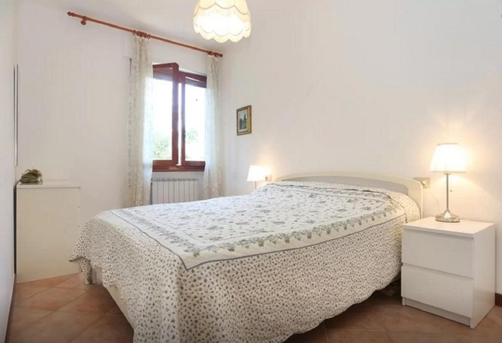 クエルチェタにあるApartment Michelangeloの白いベッドルーム(ベッド1台、窓付)