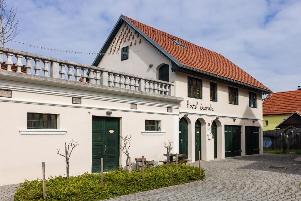 um edifício branco com um telhado vermelho em Hostel Gabronka em Bistrica ob Sotli