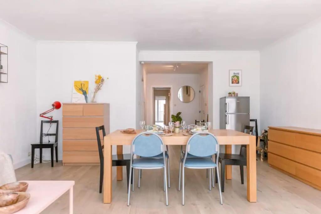 ein Esszimmer mit einem Holztisch und blauen Stühlen in der Unterkunft ruim appartement aan zee in Ostende