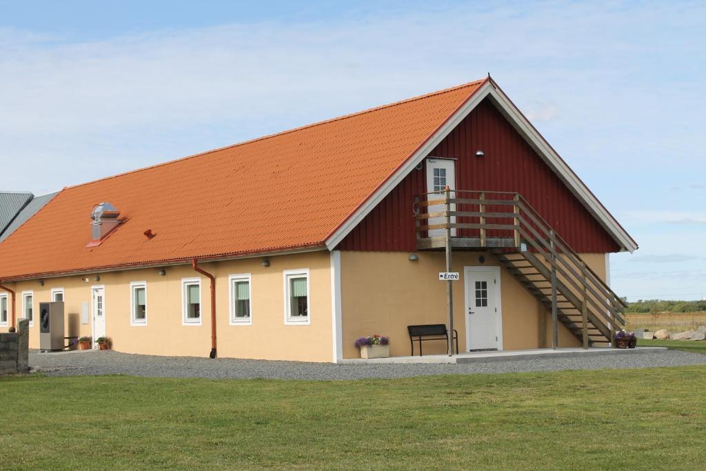 a large barn with an orange roof at Kärraton Vandrarhem in Åhus