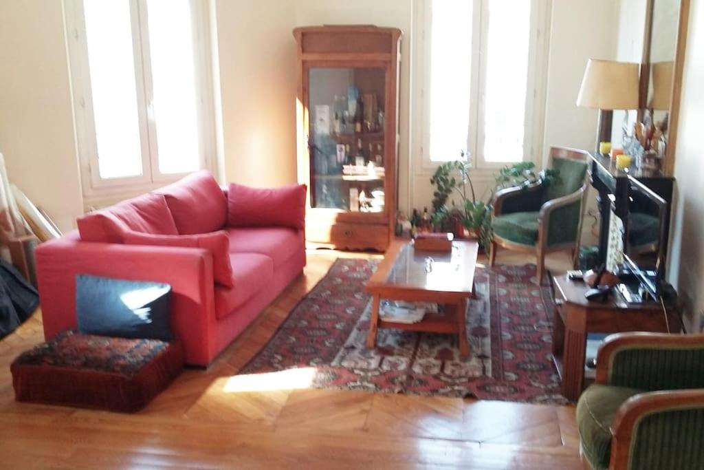 sala de estar con sofá rojo y mesa en Large and cosy, Paris-Ouest, en Levallois-Perret