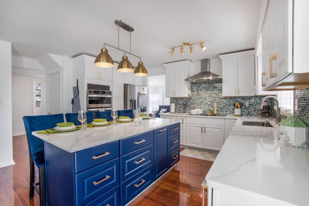 a large kitchen with blue cabinets and white appliances at Modern Oasis Near Washington DC in Silver Spring