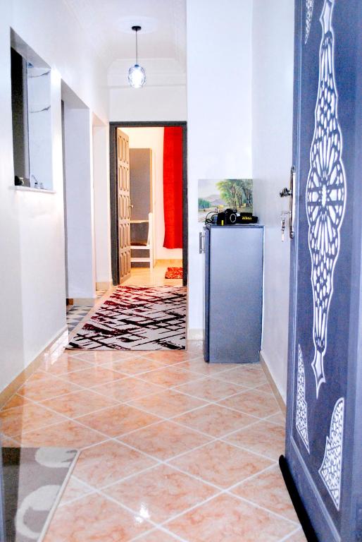 a hallway with a tile floor and a refrigerator at Airport apartment 1 