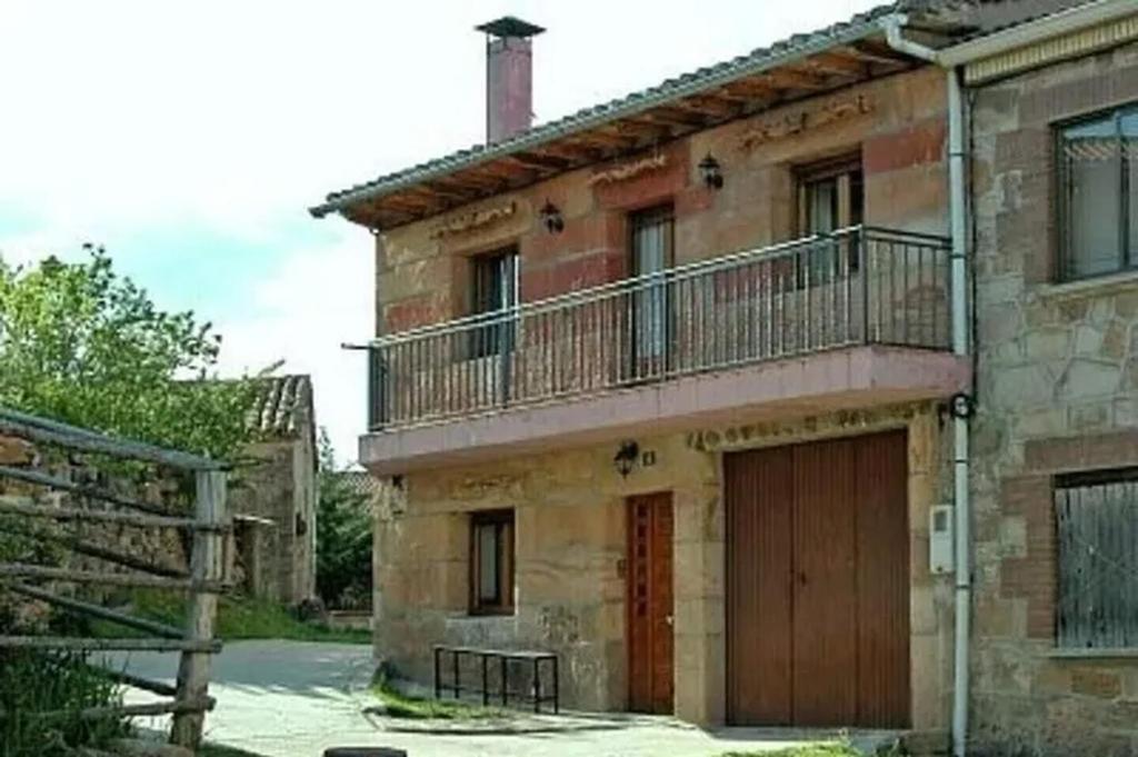 Casa de piedra antigua con balcón y garaje en Casa Rural Los Roblones, en Rabanera del Pinar