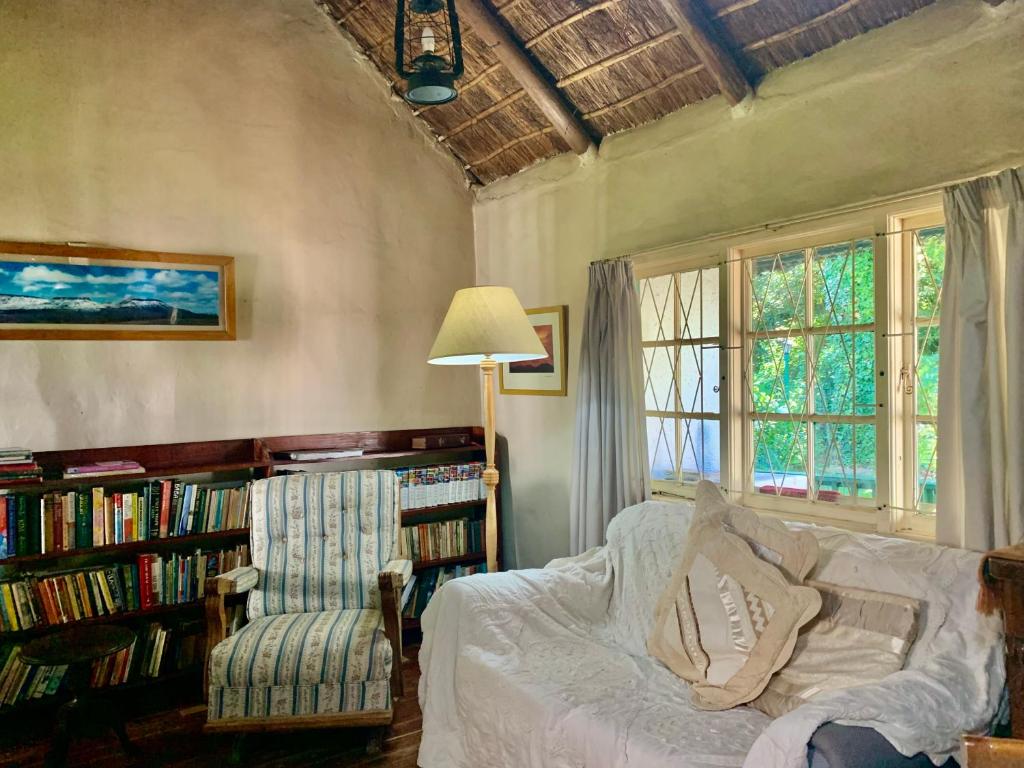 um quarto com uma cama e uma estante de livros com livros em Back o' the Moon Holiday cottage em Hogsback