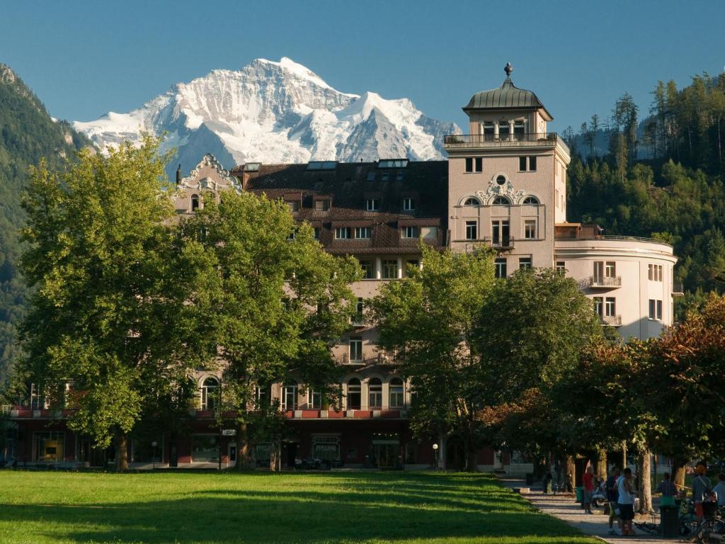 a building with a snow covered mountain in the background at Apartment Modern by Interhome in Interlaken