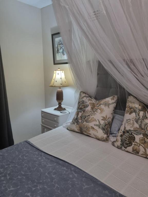a bedroom with a bed with a canopy and a lamp at Clivedon Cottage in Sunland