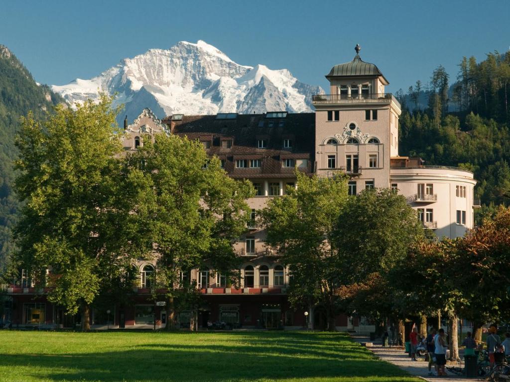 a building with a snow covered mountain in the background at Apartment Victoria View by Interhome in Interlaken