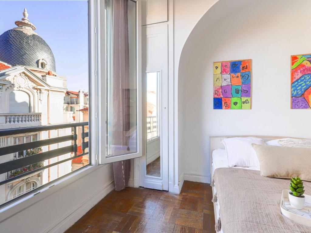 1 dormitorio con cama y ventana grande en Apartment Les Colisées by Interhome, en Niza