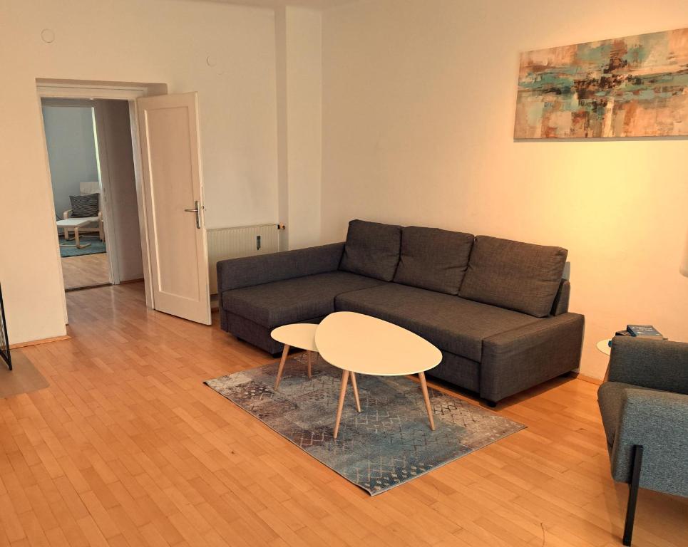 ein Wohnzimmer mit einem Sofa und einem Tisch in der Unterkunft Flataid Apartment Elisabethinergasse in Graz