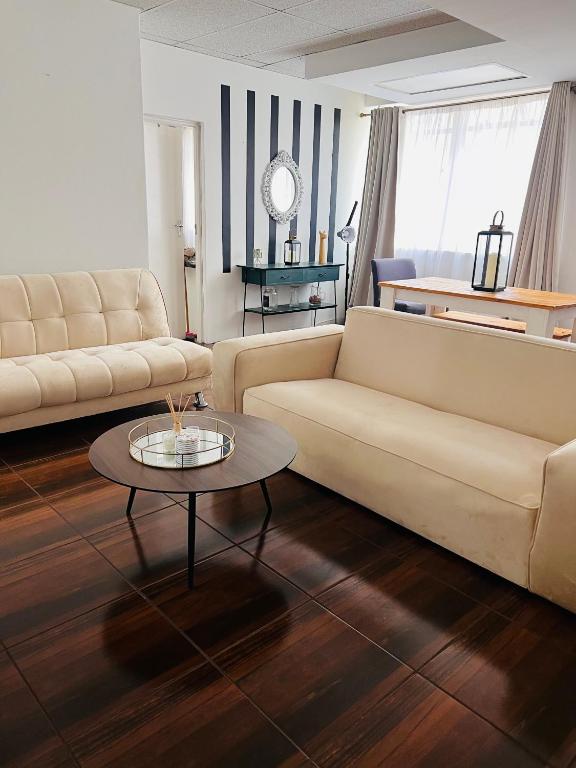 ein Wohnzimmer mit 2 Sofas und einem Couchtisch in der Unterkunft Luxury Self-Catering Apartment in Johannesburg