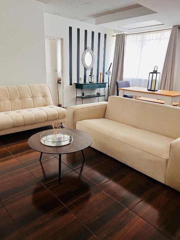 a living room with two couches and a coffee table at Luxury Self-Catering Apartment in Johannesburg