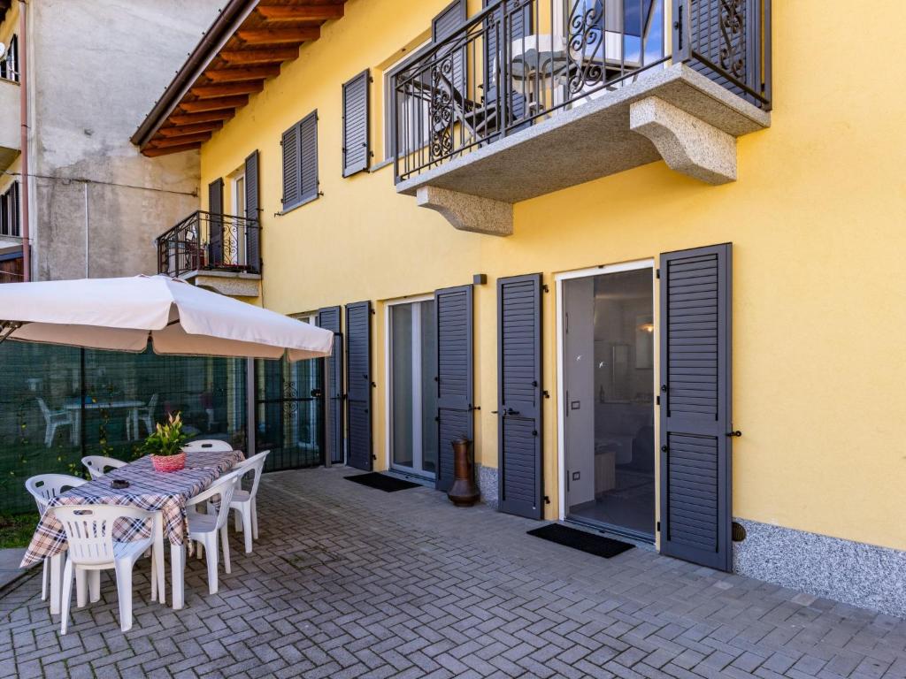 patio ze stołem i krzesłami oraz budynek w obiekcie Holiday Home Carmen by Interhome w mieście Brissago Valtravaglia