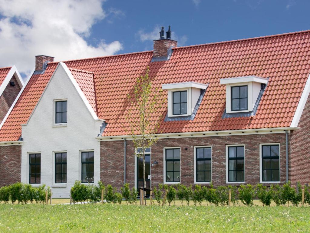 ColijnsplaatにあるHoliday Home Ganuenta by Interhomeのオレンジ色の屋根の家