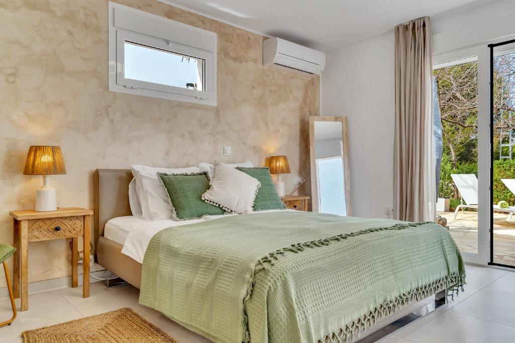 een slaapkamer met een bed met een groen dekbed bij Casa La Naranja Boutique Hotel B&B LaCasita in Pedreguer