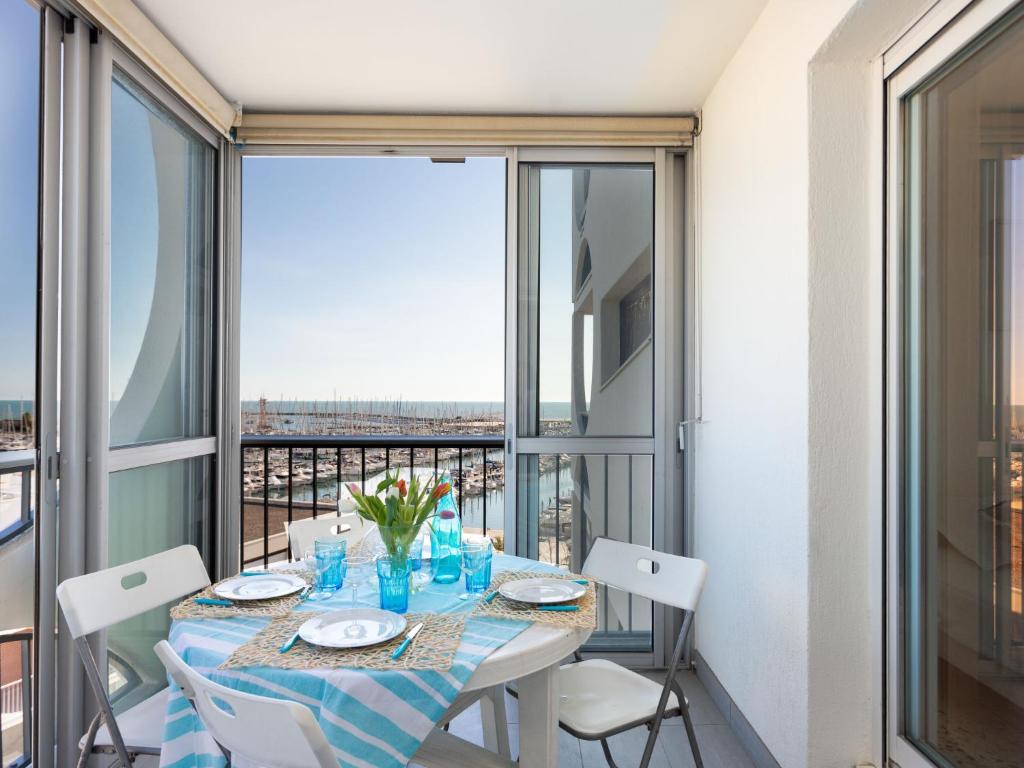 a dining room with a table and chairs and a balcony at Apartment La Tour Fenestrelle by Interhome in La Grande Motte