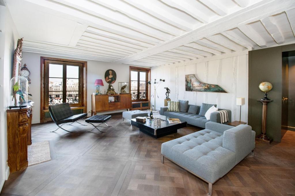 a living room with a couch and a table at Ile Saint Louis & Direct River Views - CityApartmentStay in Paris