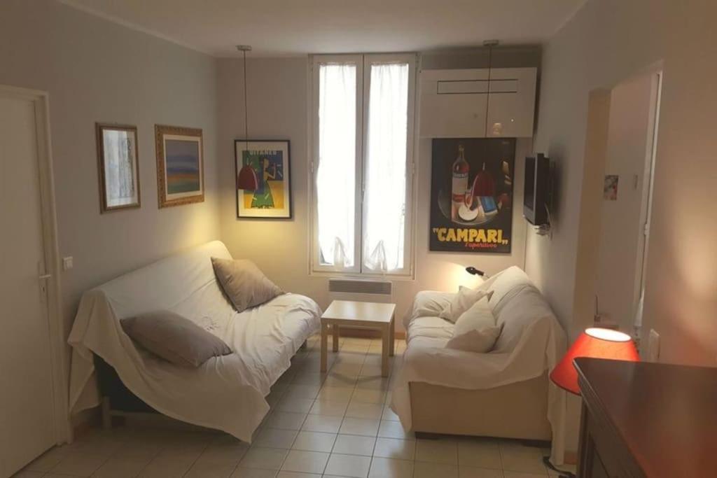 a living room with two white couches and a window at Casa Charlotte nel cuore di Cannes in Cannes