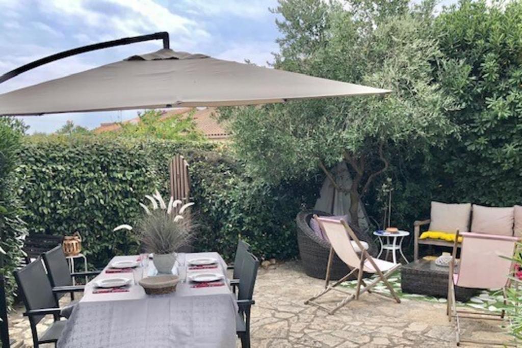 a table with an umbrella in a garden at Between sea and Garrigues! in Vic-la-Gardiole