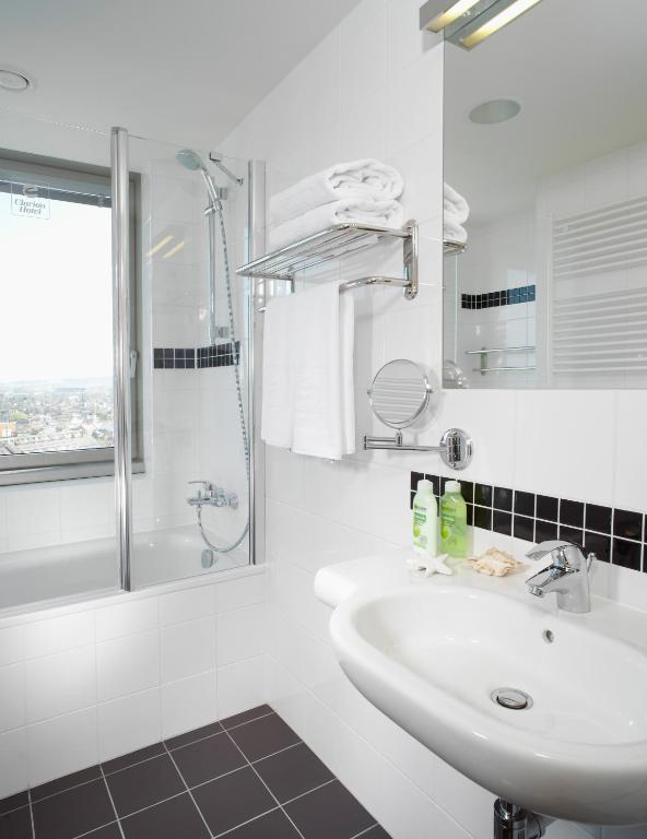a white bathroom with a sink and a shower at Clarion Congress Hotel České Budějovice in České Budějovice